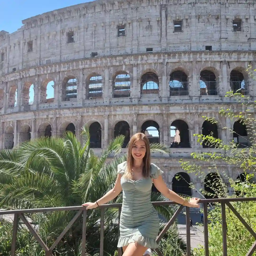 Viajera disfrutando de las vistas al Coliseo Romano desde un mirador cercano en Roma, Italia.