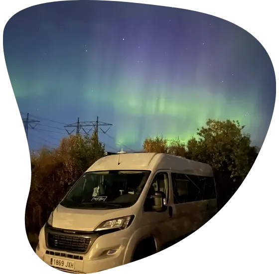 Furgoneta camper de Viajeros con Ruta bajo una aurora boreal durante un viaje por libre.