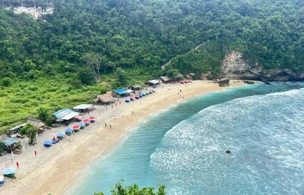 Playa de arena blanca y agua turquesa rodeada de palmeras en Virgin Beach, Bali.