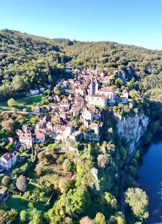 Pueblo medieval en acantilado, río y naturaleza.