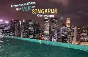 Vistas panorámicas nocturnas de Singapur desde una piscina infinita.