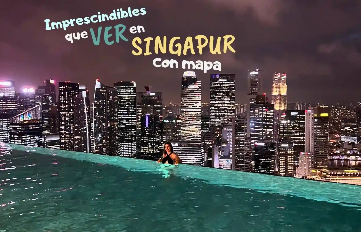Vistas panorámicas nocturnas de Singapur desde una piscina infinita.